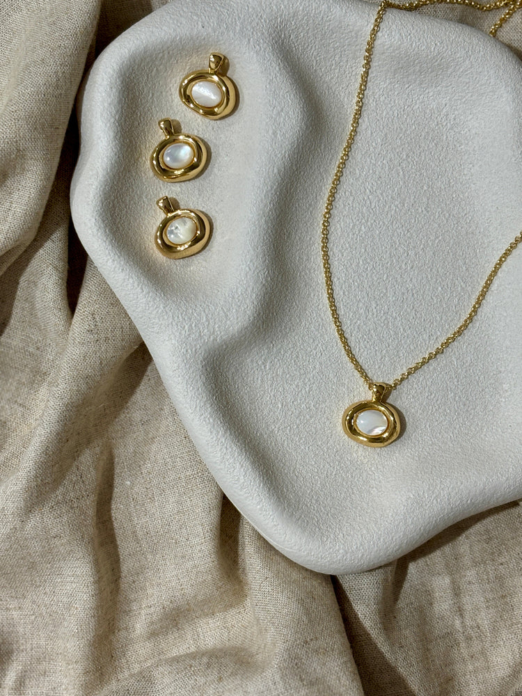 Gold filled freshwater pearl earrings and necklace by Tide & Stone Jewellery, styled on cream fabric